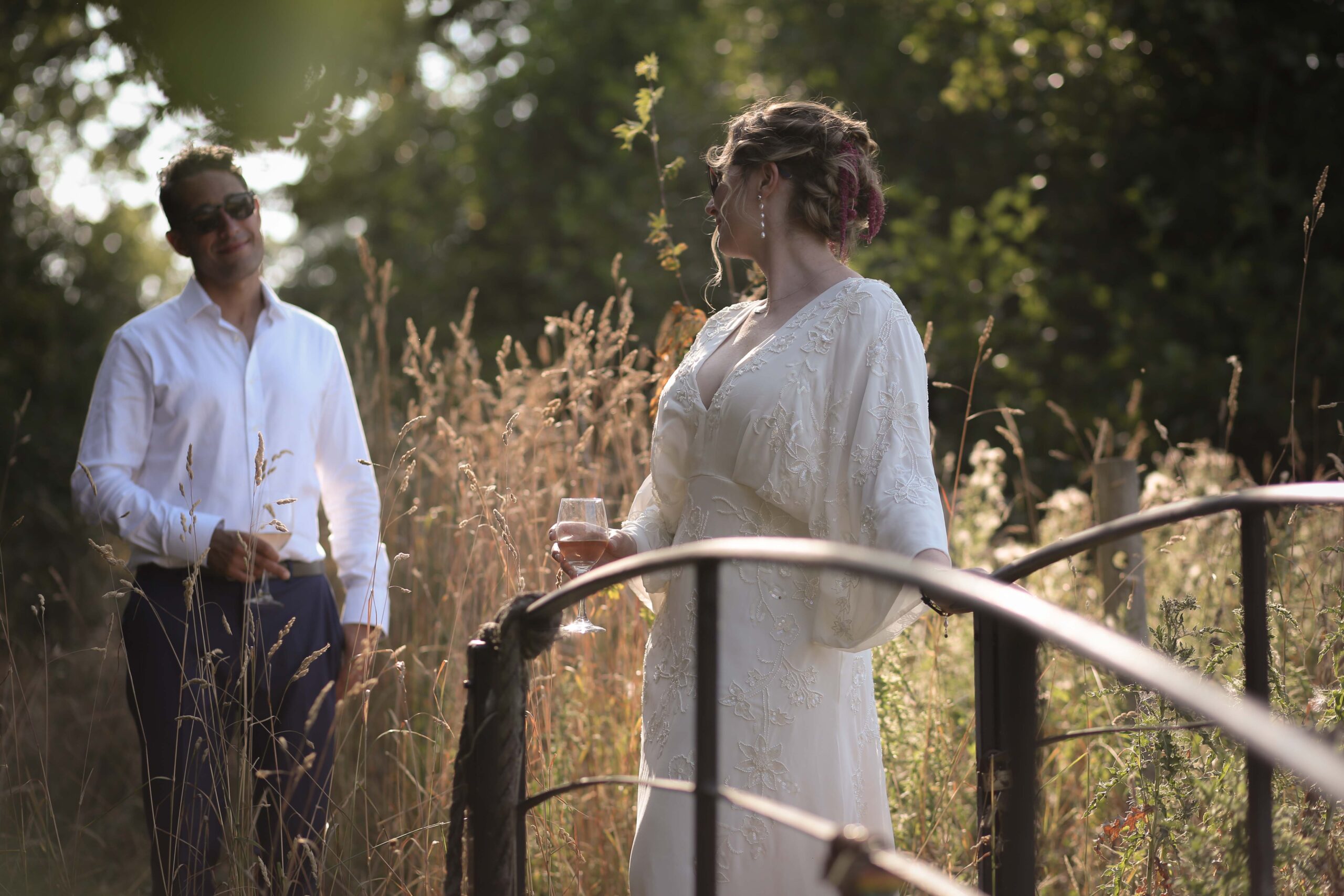 bride and groom in a meadow beside a lake