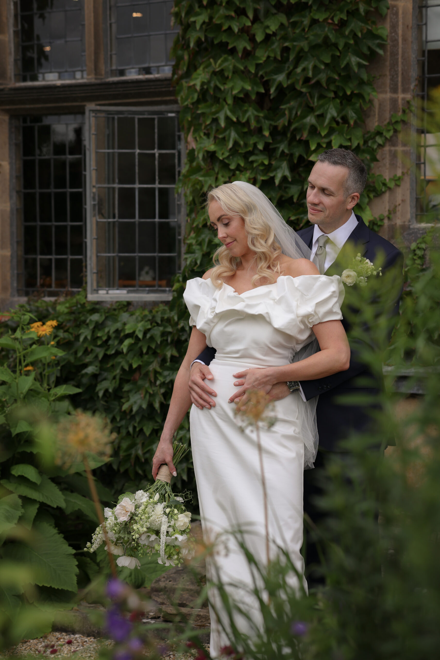 Bridal couple embrace outide luxury country house